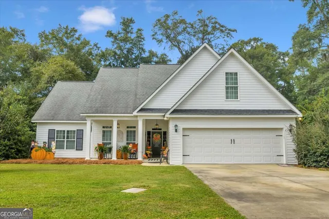 a front view of a house with a garden and yard