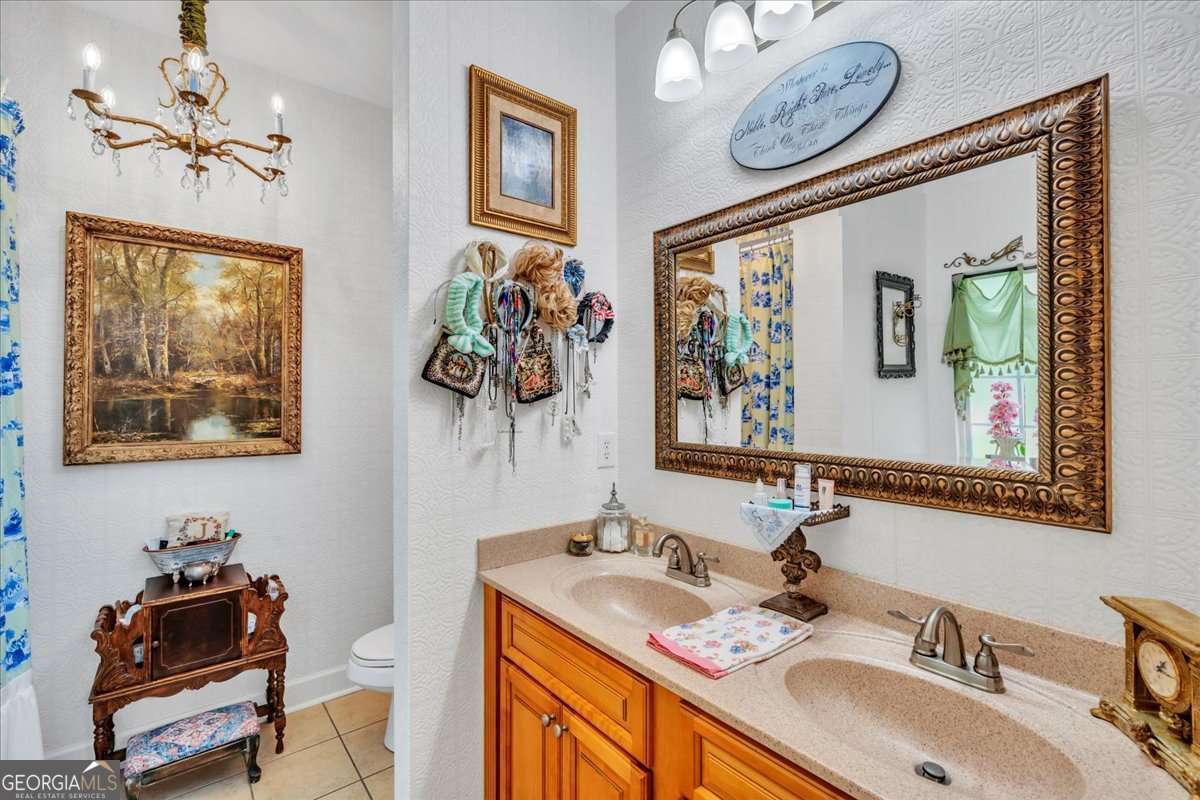 153 Landing Road Cordele, GA 31015 - Photo 24 of 62 a bathroom with a sink mirror and a painting on the wall