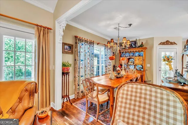 a very nice looking dining room with a large window and chandelier