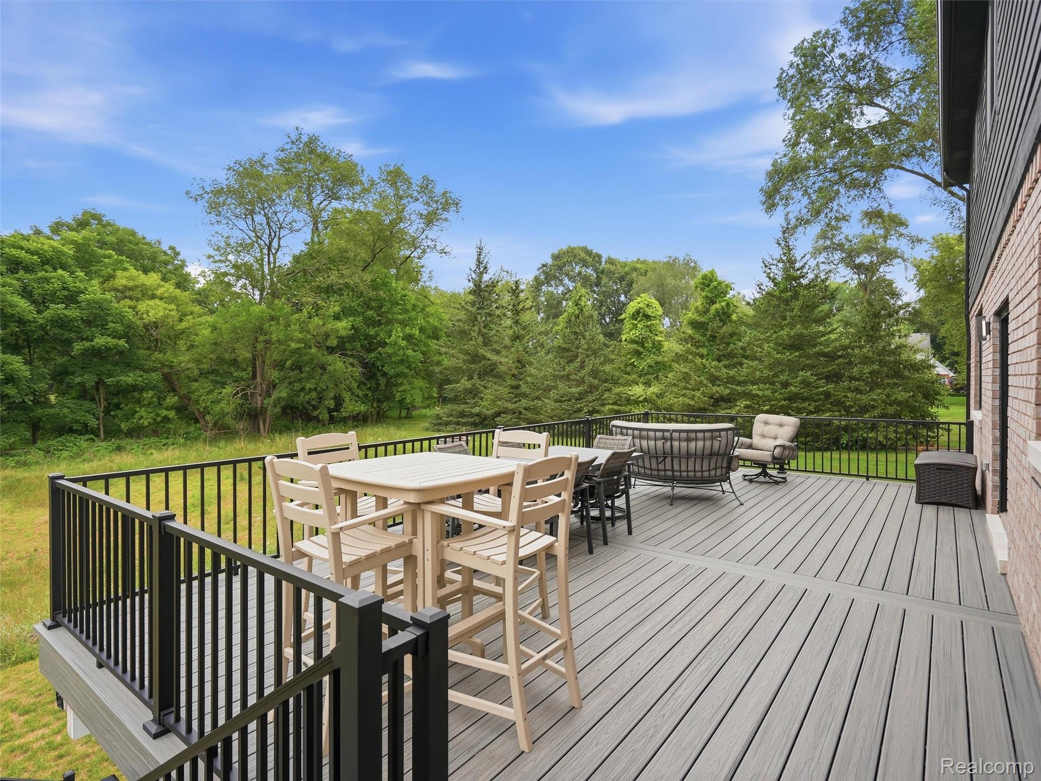 3007 28 Mile Road Washington, MI 48094 - Photo 51 of 69 Spacious outdoor deck featuring composite decking, black metal railings, and a brick exterior wall