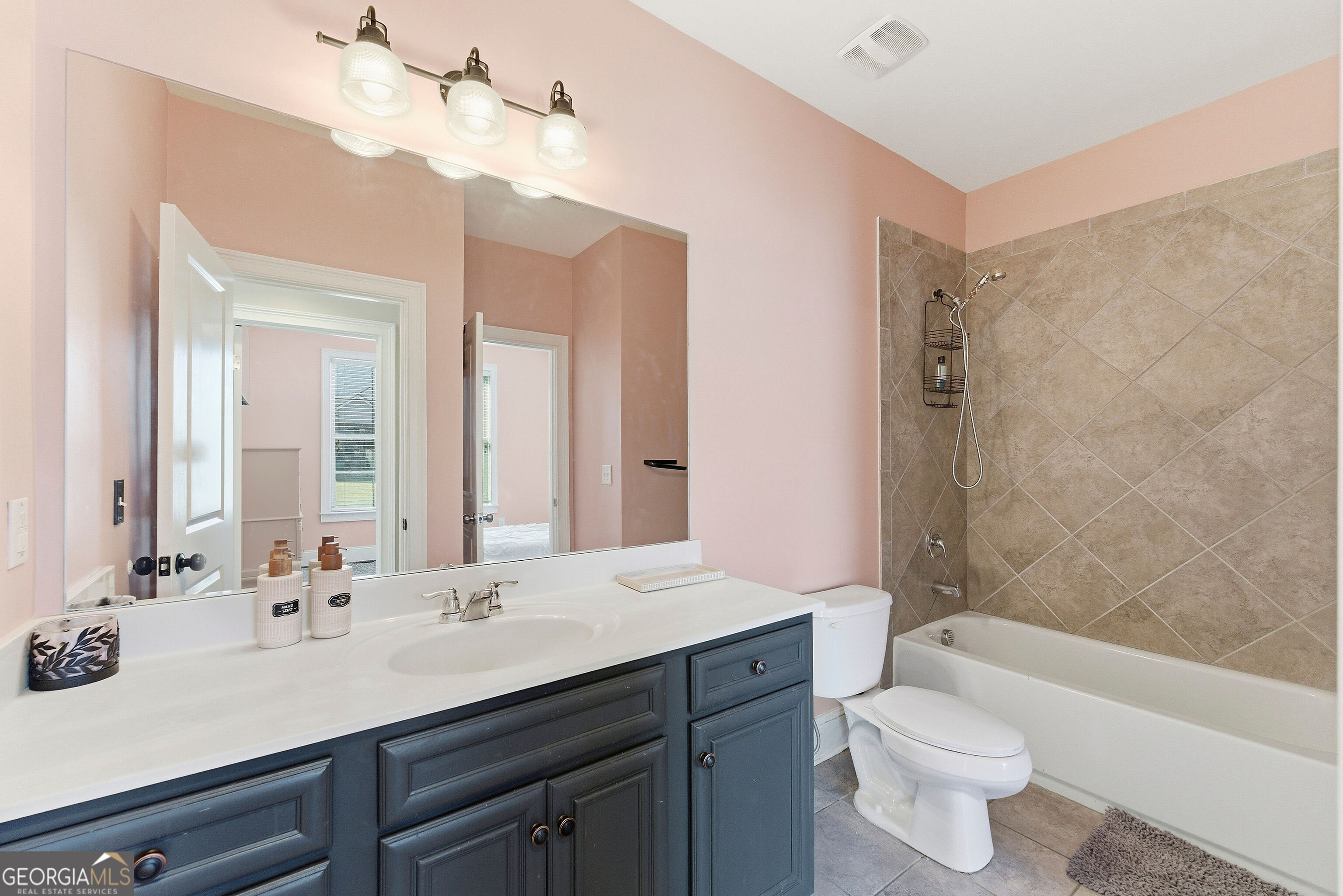 301 Lowell Street Atlanta, GA 30331 - Photo 7 of 28 a bathroom with a sink a toilet a mirror a bathtub and shower