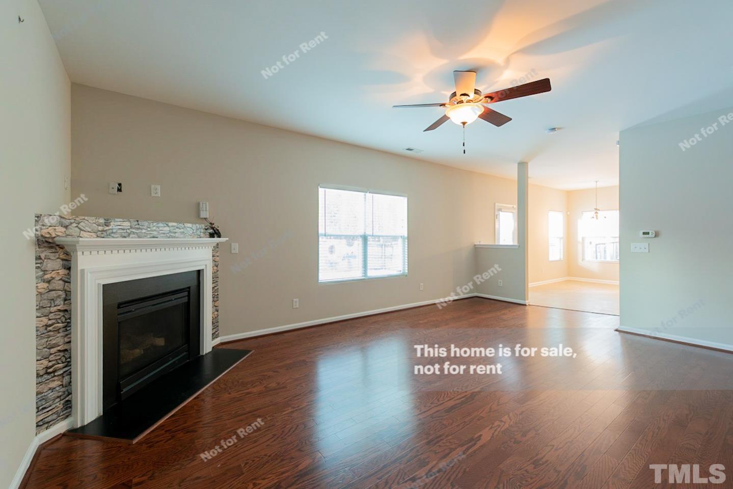 6328 Bunker Hill Drive Raleigh, NC 27610 - Photo 11 of 22 a view of an empty room with wooden floor fireplace and a window