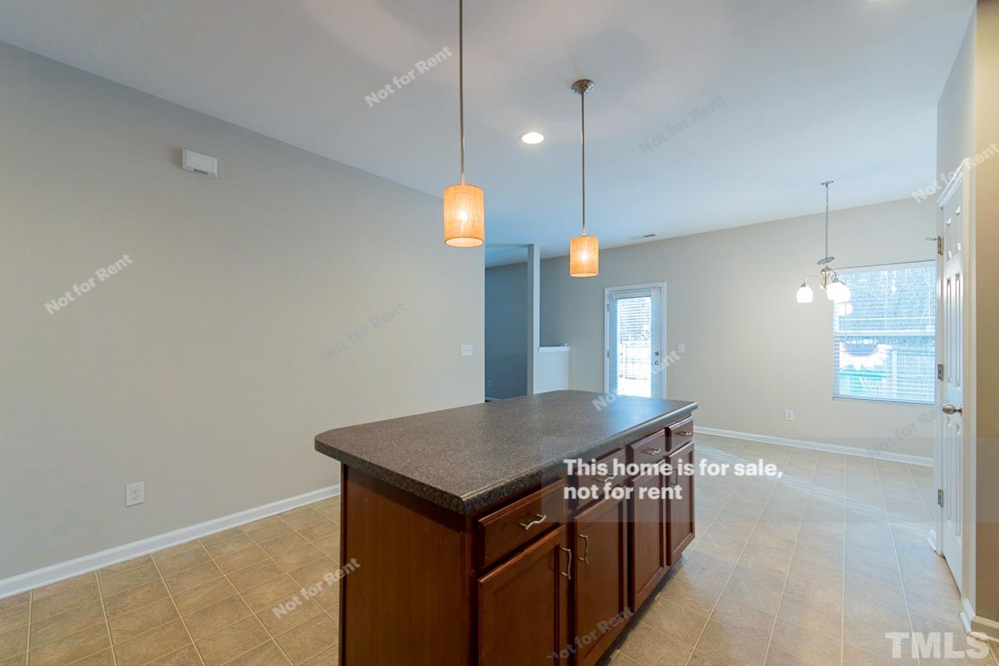 6328 Bunker Hill Drive Raleigh, NC 27610 - Photo 9 of 22 a kitchen with a kitchen island a stove and a wooden floor