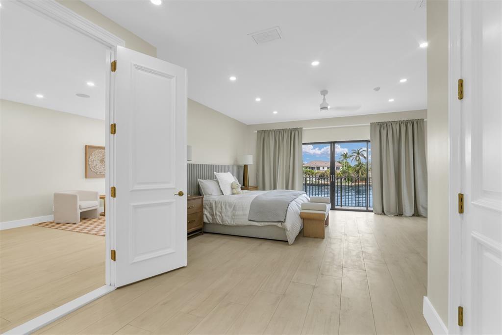 319 South Riverside Drive Pompano Beach, FL 33062 - Photo 36 of 88 a spacious bedroom with a large bed and a chandelier