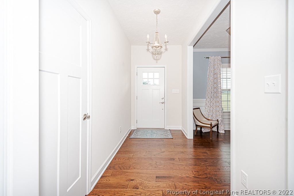 5641 Wade-Stedman Road Wade, NC 28395 - Photo 12 of 46 a view of a hallway with wooden floor and a bathroom