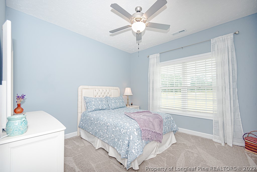 5641 Wade-Stedman Road Wade, NC 28395 - Photo 31 of 46 a bedroom with a bed and a chandelier