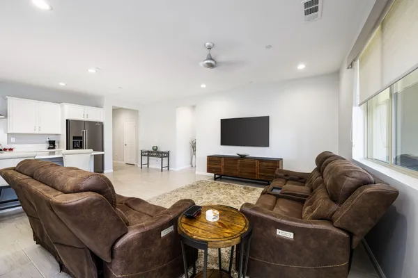 a kitchen with stainless steel appliances a table chairs refrigerator and a sink
