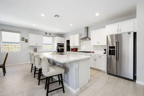 a kitchen with a sink a stove and chairs