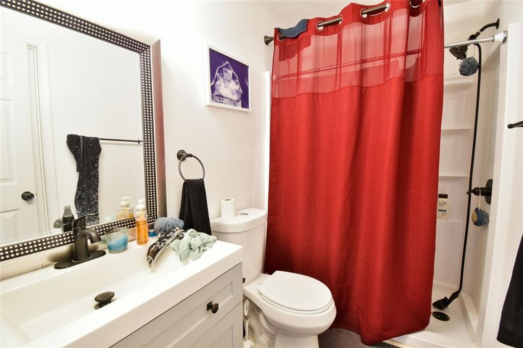 12140 Dominion Drive Hampton, GA 30228 - Photo 18 of 52 a bathroom with a sink a toilet and shower curtain