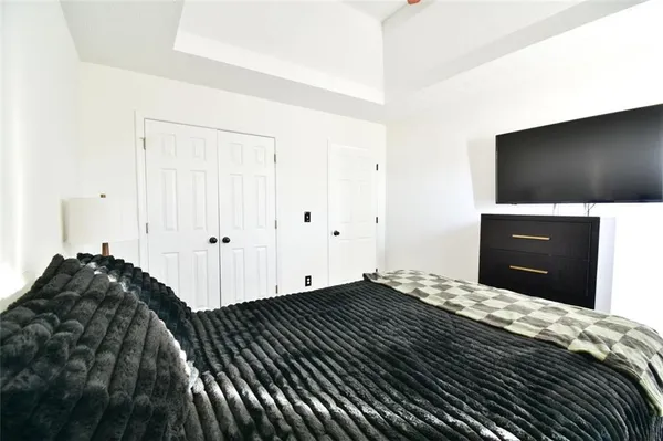 a bedroom with a bed and a flat tv screen next to a window