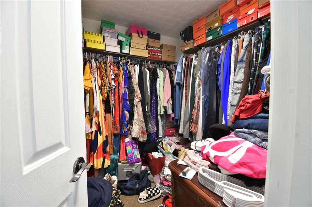12140 Dominion Drive Hampton, GA 30228 - Photo 51 of 52 a view of walk in closet with clothes and shoes
