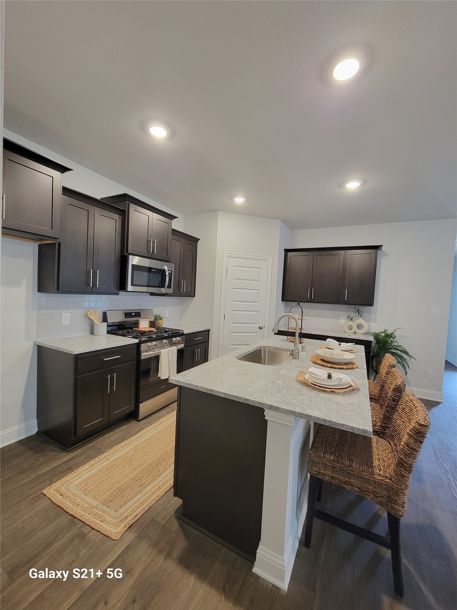 9460 Hard Rock Road Conroe, TX 77303 - Photo 3 of 17 a kitchen with stainless steel appliances a stove a sink a microwave a refrigerator and cabinets