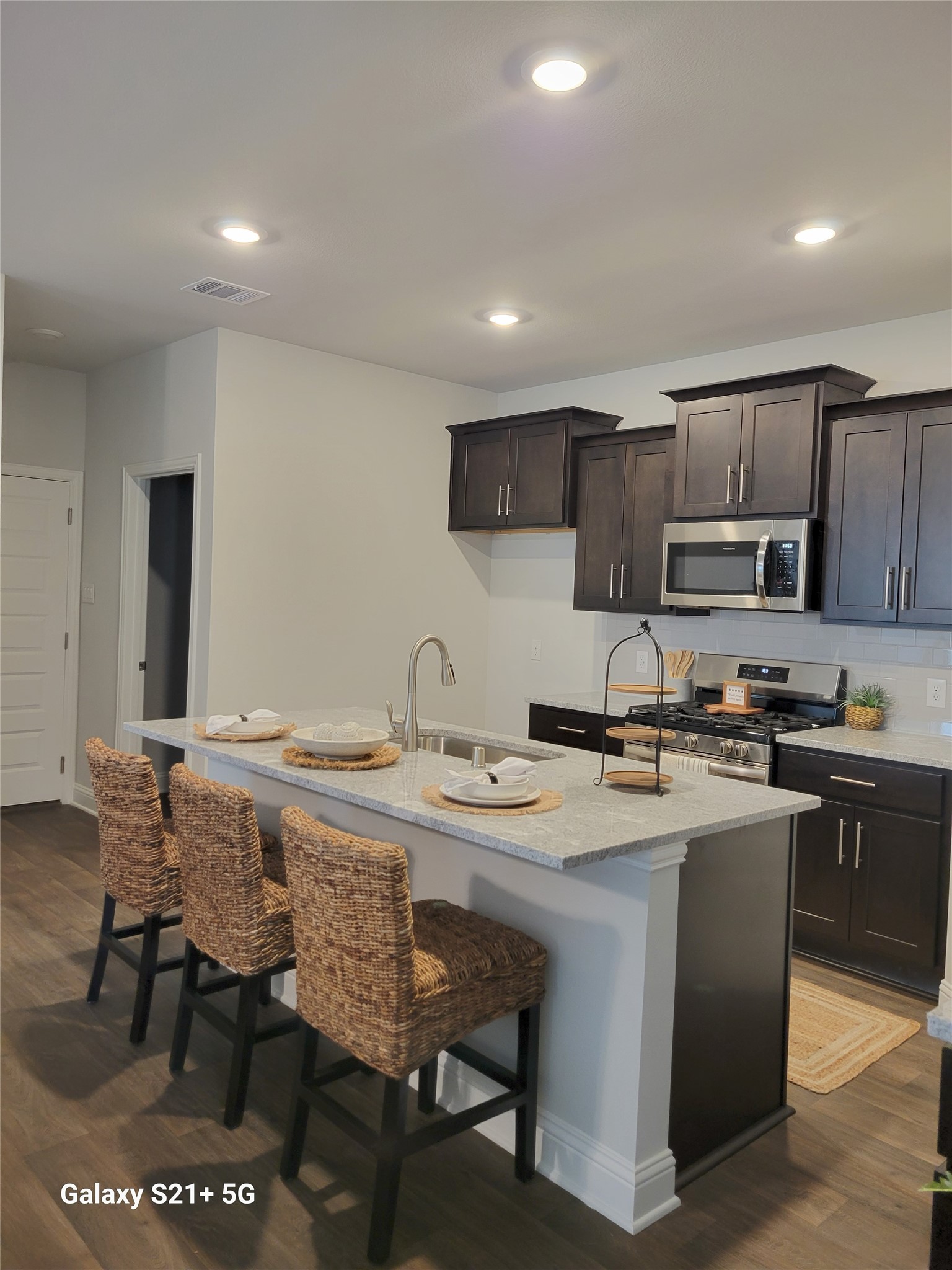 9460 Hard Rock Road Conroe, TX 77303 - Photo 4 of 17 a kitchen with stainless steel appliances granite countertop a stove a sink a microwave a refrigerator and cabinets