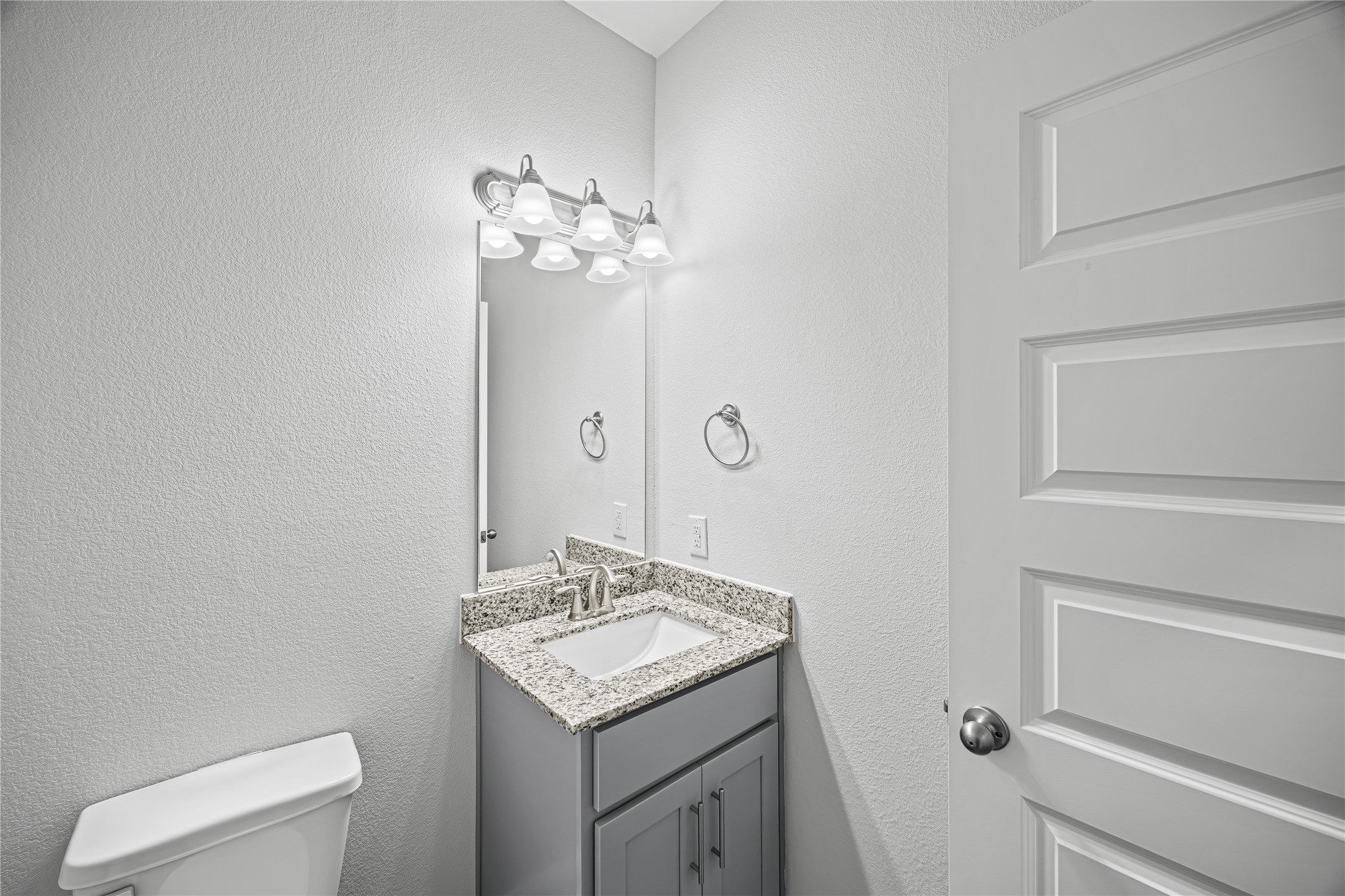 9460 Hard Rock Road Conroe, TX 77303 - Photo 7 of 17 a bathroom with a granite countertop sink a toilet and a mirror
