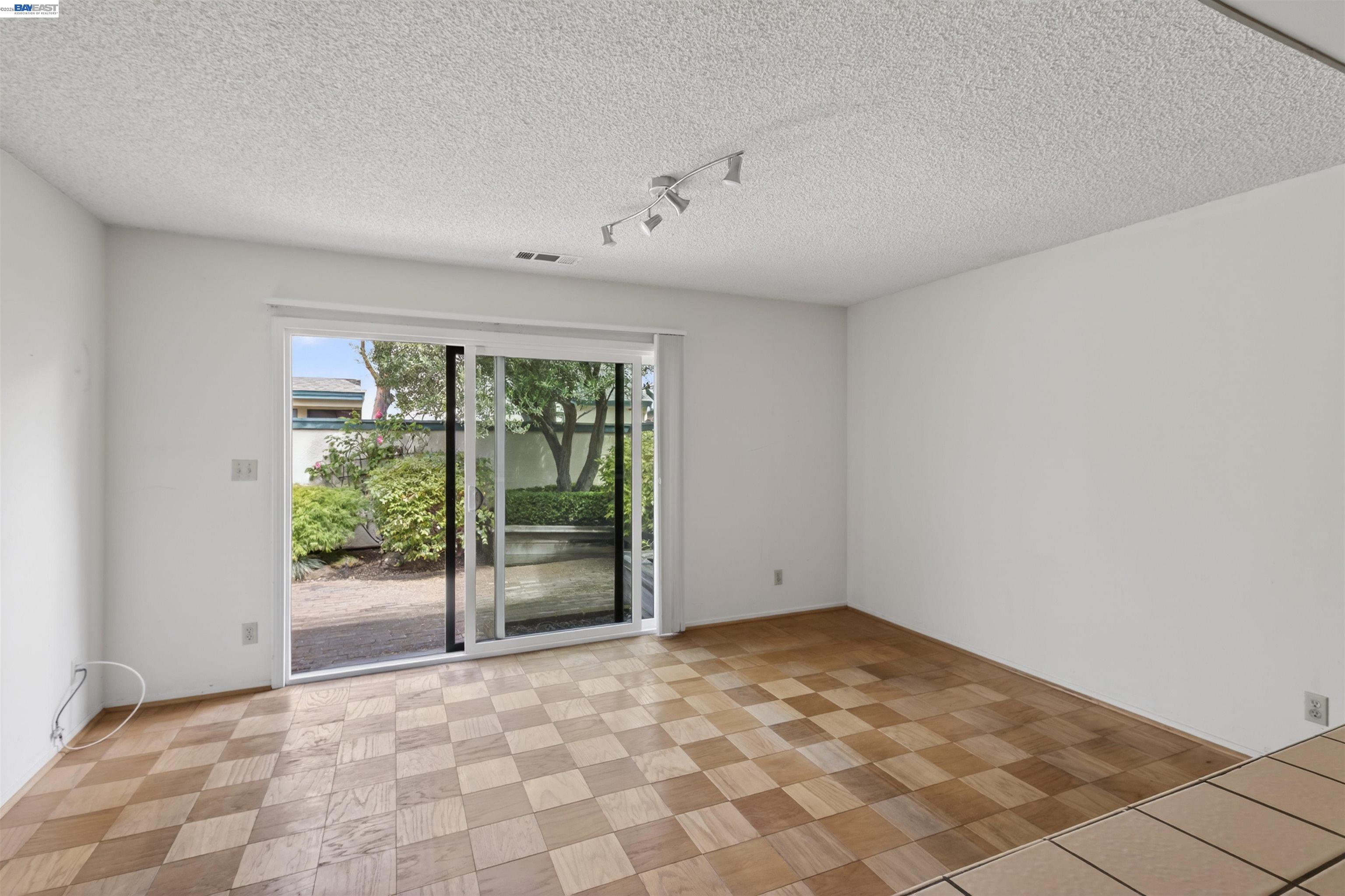 202 Baywood Road Alameda, CA 94502 - Photo 16 of 26 a view of an empty room with wooden floor and a window