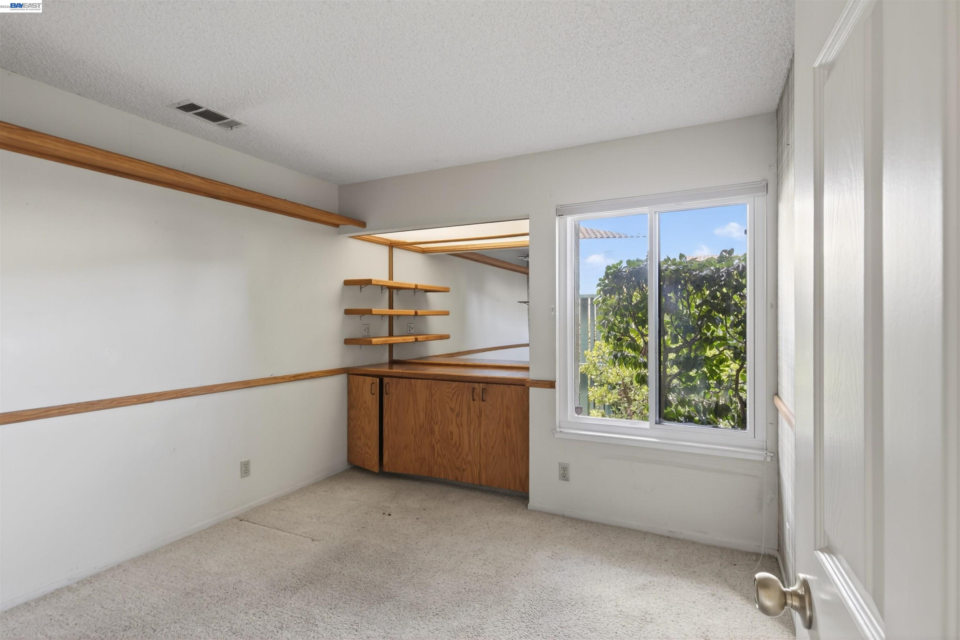 202 Baywood Road Alameda, CA 94502 - Photo 17 of 26 a view of an empty room with window and cabinet