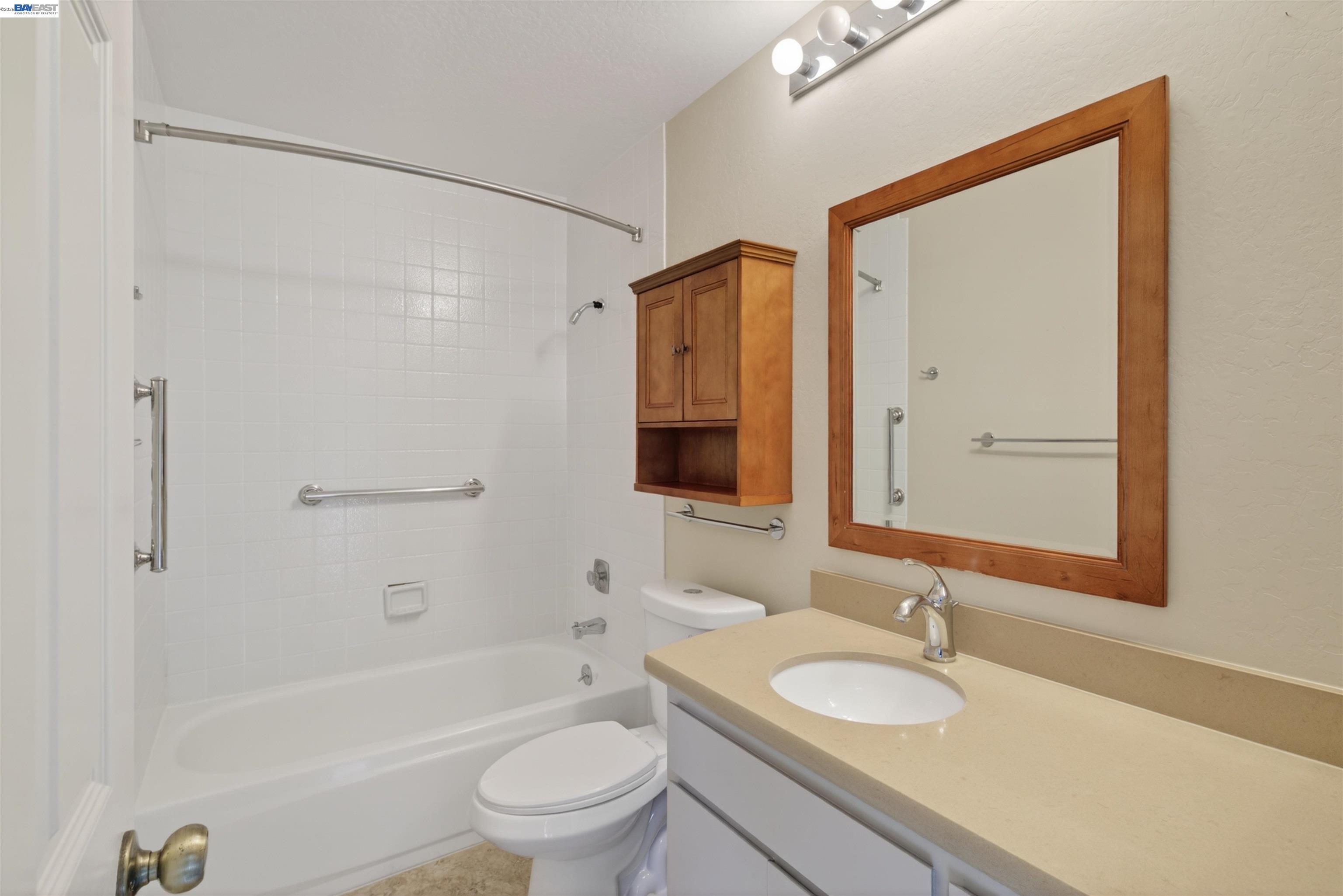 202 Baywood Road Alameda, CA 94502 - Photo 19 of 26 a bathroom with a granite countertop sink toilet mirror vanity and bathtub