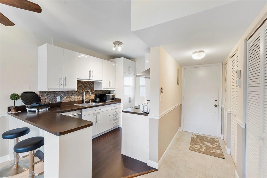 5401 Northwest 2nd Avenue, Unit 322 Boca Raton, FL 33487 - Photo 1 of 7 a kitchen with stainless steel appliances a stove a sink a refrigerator and cabinets