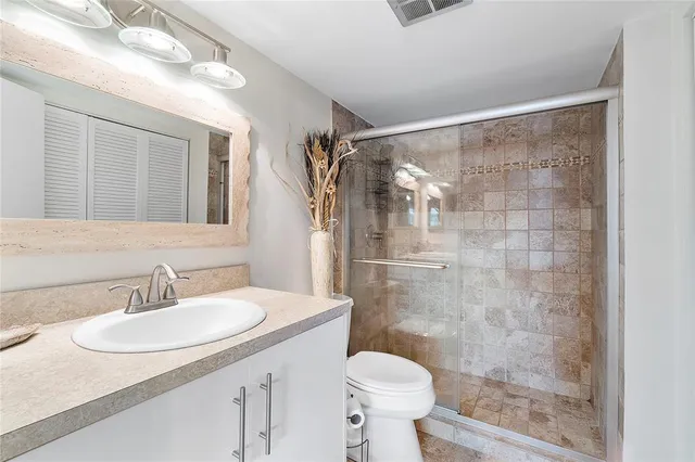 a bathroom with a sink toilet a mirror and shower