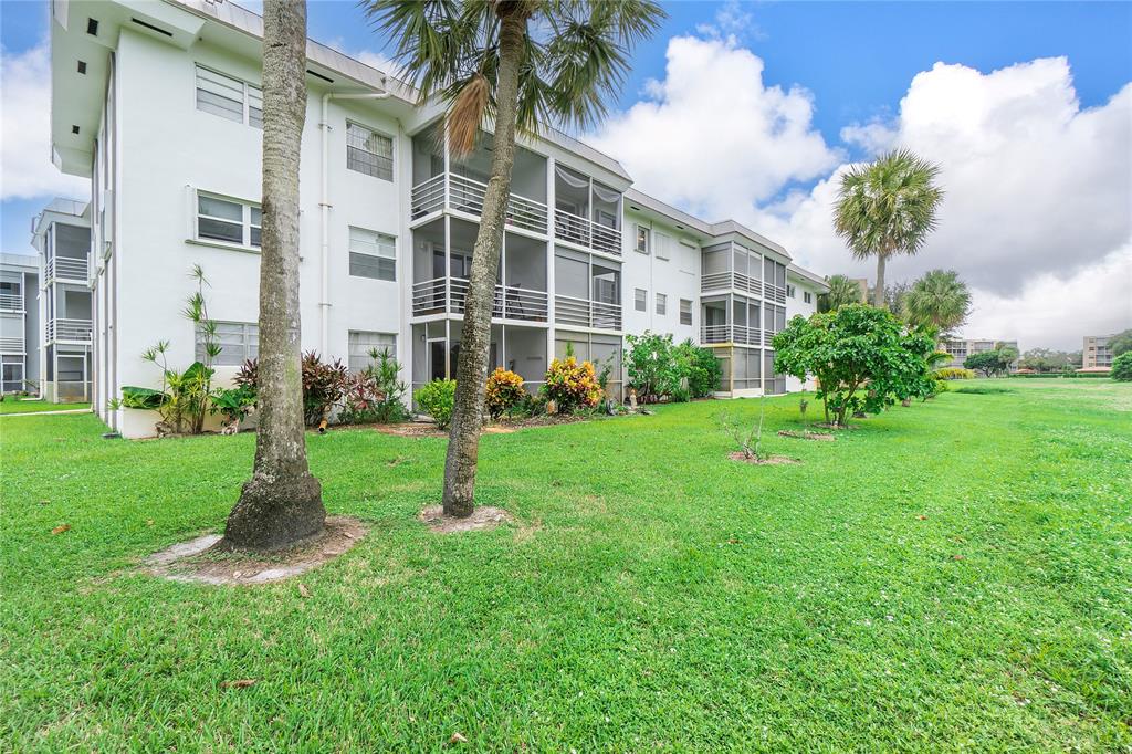 5401 Northwest 2nd Avenue, Unit 322 Boca Raton, FL 33487 - Photo 7 of 7 a view of a building with a yard