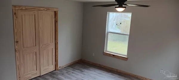 an empty room with windows and closet