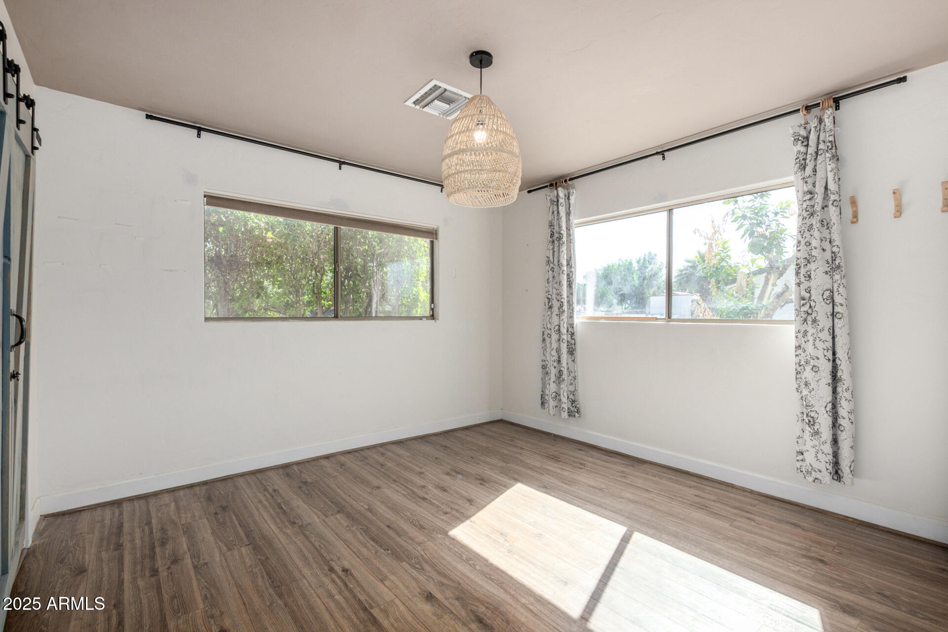 3718 North 36th Street Phoenix, AZ 85018 - Photo 11 of 37 a view of empty room with wooden floor and fan