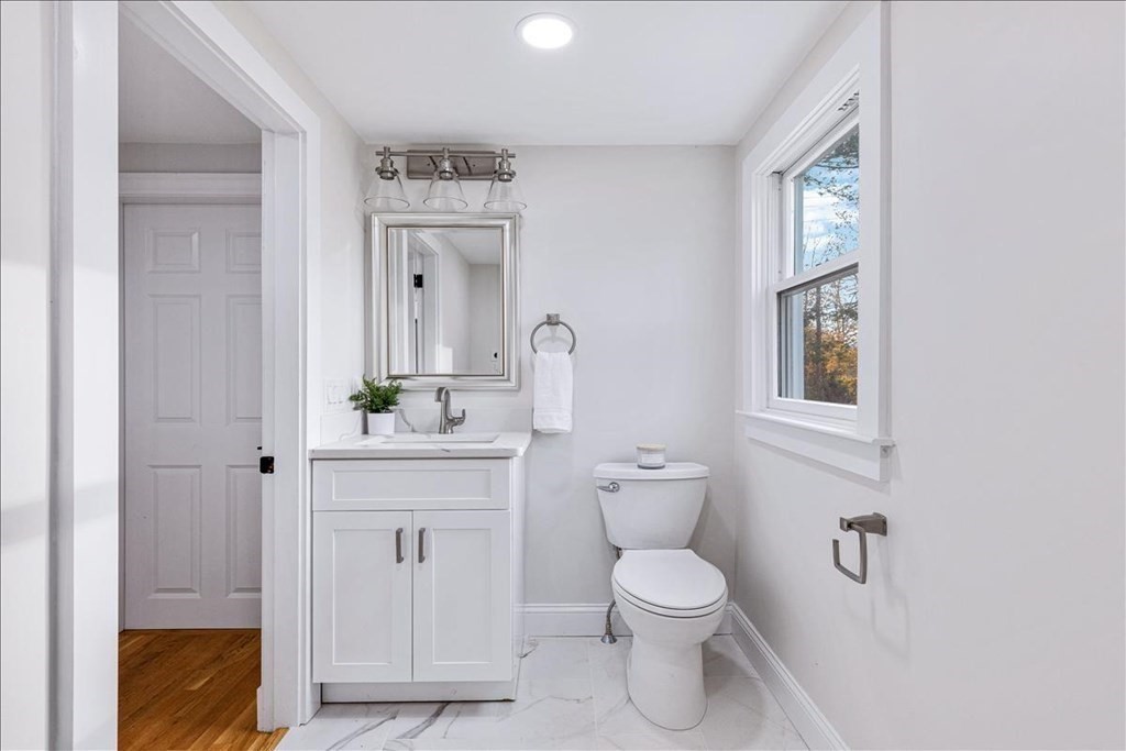964 Main Street Hanover, MA 02339 - Photo 17 of 35 a bathroom with a toilet a sink and mirror
