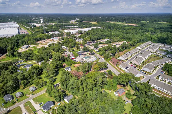 an aerial view of residential houses with outdoor space and trees