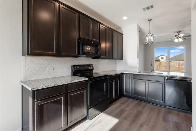 a kitchen with granite countertop stainless steel appliances and cabinets