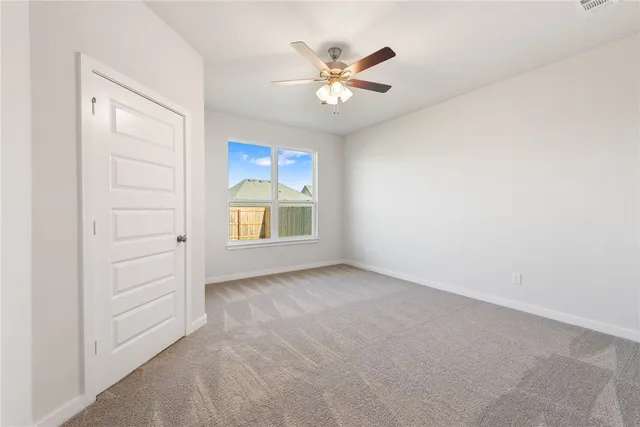 a view of an empty room with a ceiling fan