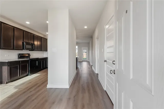 a view of a kitchen with wooden floor and electronic appliances