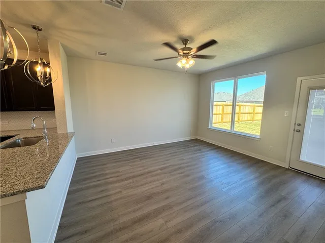 a view of a livingroom with wooden floor and a ceiling fan