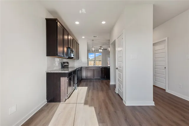 a view of kitchen with stainless steel appliances cabinets and wooden floor