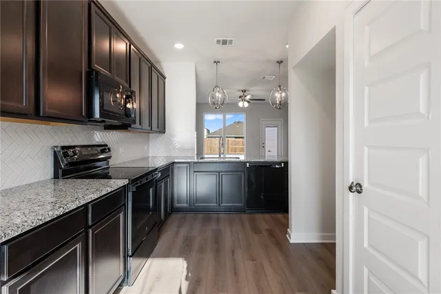 a kitchen with stainless steel appliances granite countertop a stove a sink and a refrigerator