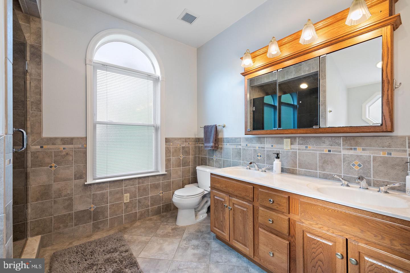 181 East Conestoga Road Wayne, PA 19087 - Photo 28 of 34 a bathroom with a granite countertop sink mirror and a toilet