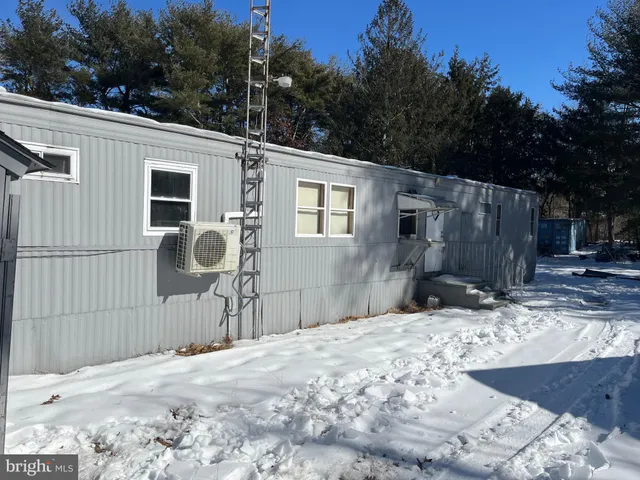 a backyard of a house with wooden fence and large trees