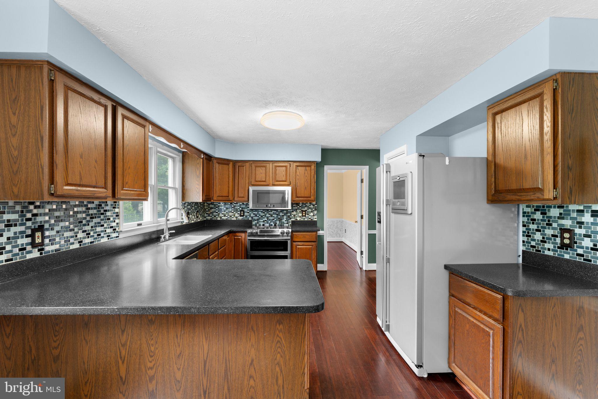 13360 Cameron Court Boston, VA 22713 - Photo 46 of 76 a living room with stainless steel appliances granite countertop a refrigerator a sink dishwasher a couches with the view and wooden floor