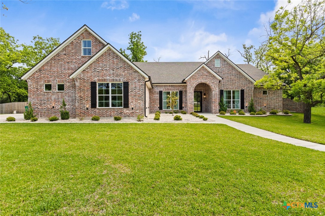 a front view of a house with yard and green space