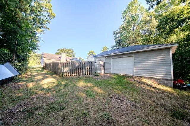 a view of a house with backyard and a tree