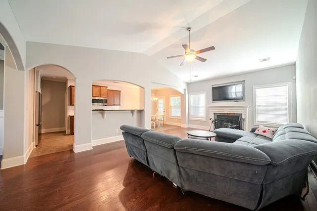 a living room with furniture fireplace and a large window