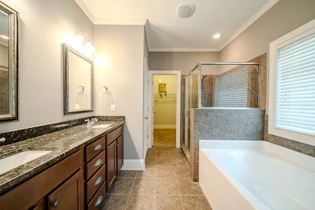 a spacious bathroom with a granite countertop tub sink and mirror