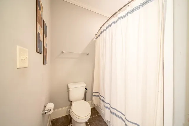 a white toilet sitting next to a shower curtain