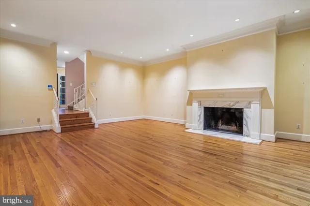 a view of empty room with wooden floor and fireplace