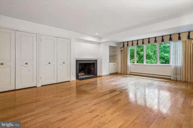 a view of empty room with wooden floor and fireplace