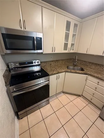 a kitchen with granite countertop a sink and a stove top oven with granite countertops