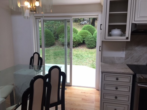 54 Drumlin Road Newton, MA 02459 - Photo 11 of 12 a close view of a kitchen island with a large window cabinets and outdoor space