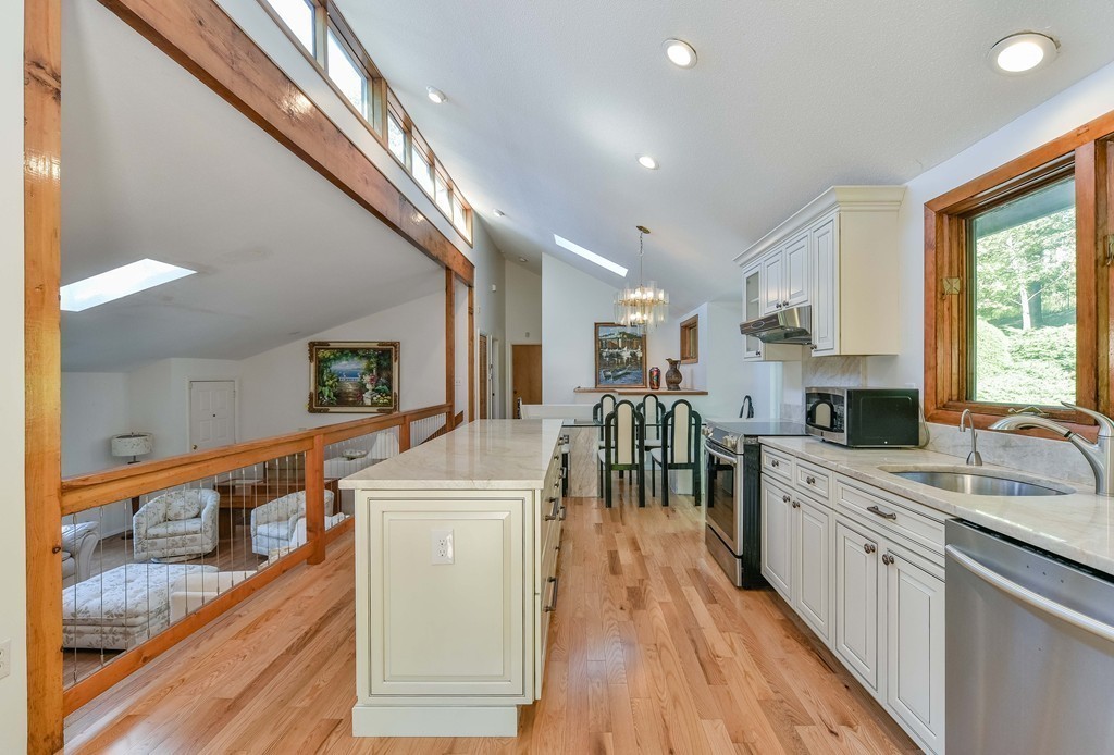 54 Drumlin Road Newton, MA 02459 - Photo 6 of 12 a large kitchen with stainless steel appliances granite countertop a lot of counter space and wooden floors