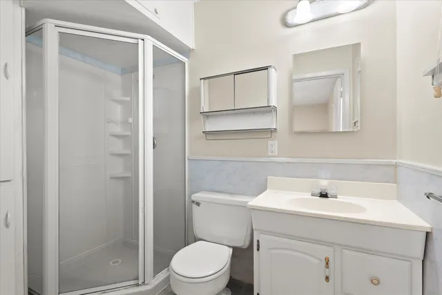 a bathroom with a sink a toilet and shower