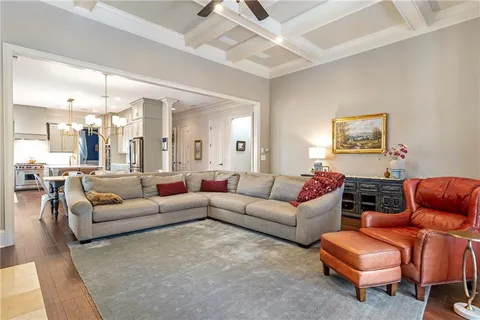 a living room with furniture a chandelier fan and a window