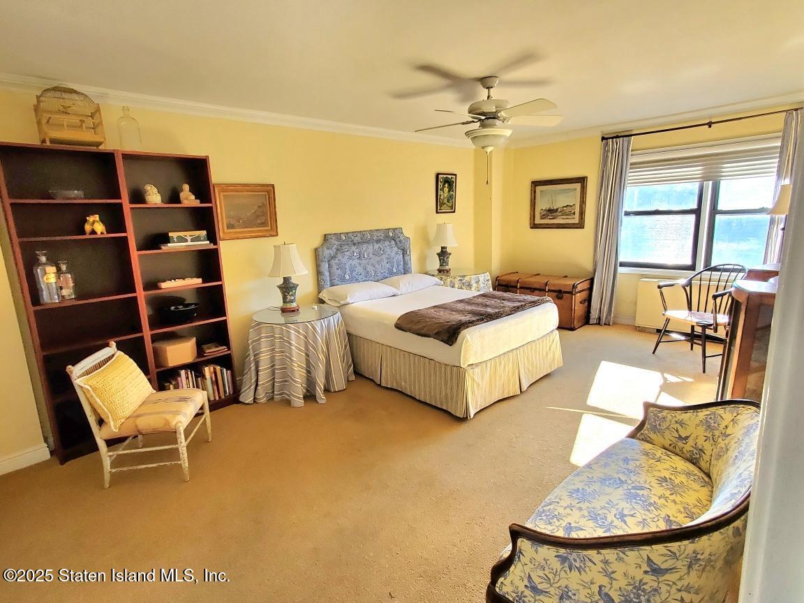 1100 Clove Road, Unit 7O Staten Island, NY 10301 - Photo 20 of 36 a spacious bedroom with a bed a couch and a dresser next to a window